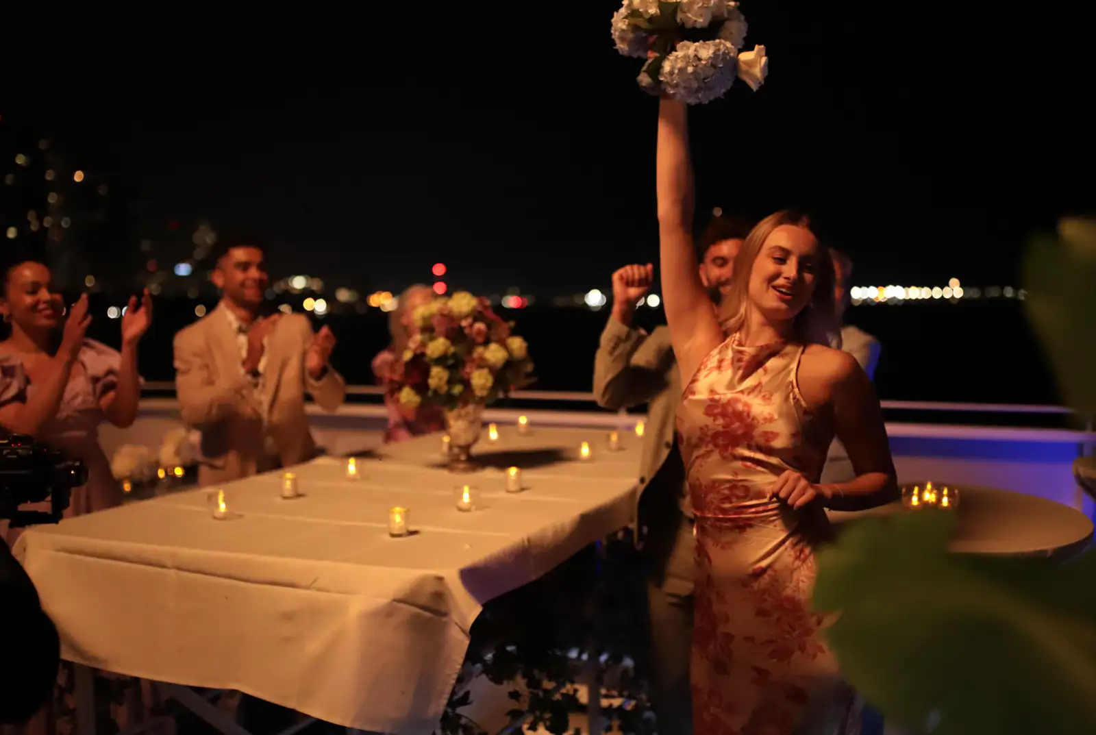 Guests celebrating with flowers and candlelit tables on deck